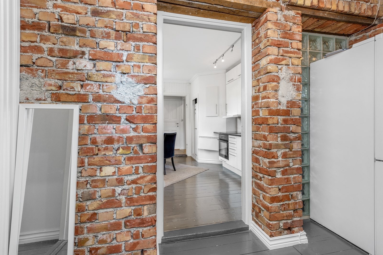 Utenfor kjøkkenet er det en gang med blottede mursteinsvegger og adkomst til fem av soverommene og ett bad. Galleribilde