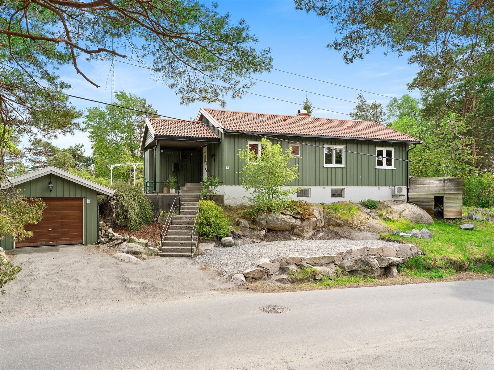 Det er asfaltert inn mot garasje og gruset plass for ekstra parkeringsmulighet. Galleribilde