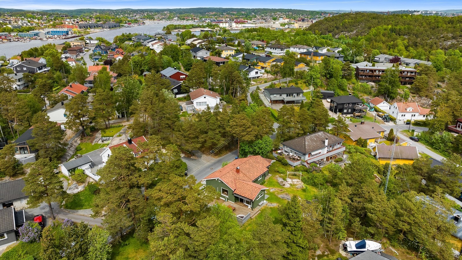 Eneboligen ligger på en liten høyde, med nokså flat tomt på baksiden av huset - perfekt for lek og moro. Galleribilde