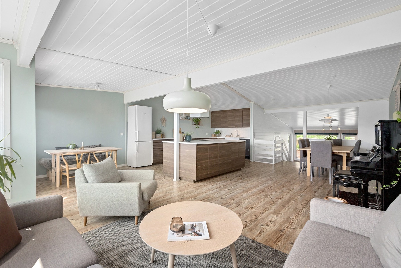 Åpen stue/kjøkkenløsning med moderne fargevalg og god plass til soner Galleribilde