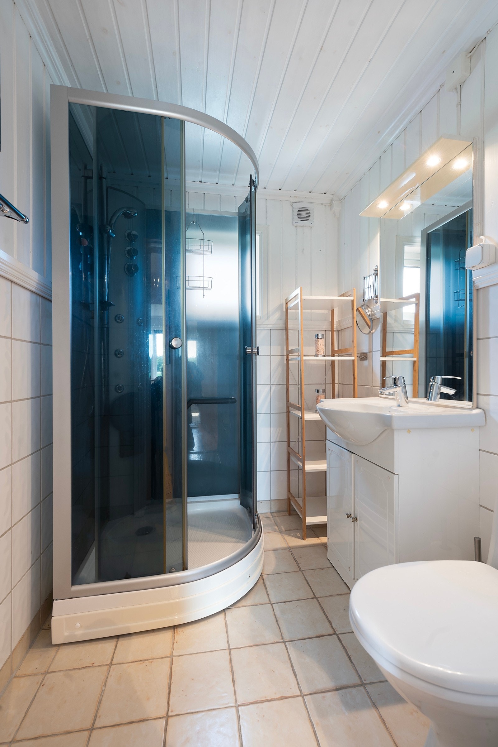 Badet har dusjkabinett, servant med skaper og et wc Galleribilde