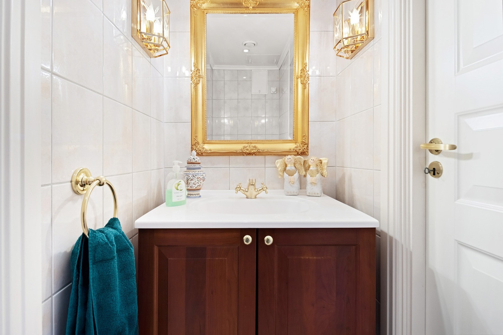 Både bad og toalettrom har mørkebrun innredning, fin belysning og speil med gullrammer. Galleribilde