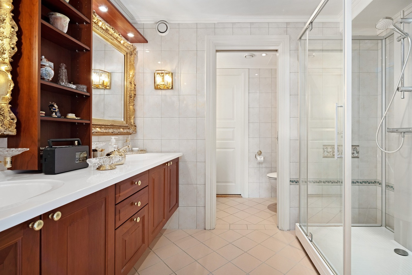 Det flislagte badet har nyere dusjkabinett og skyvedør mot toalettrom. Galleribilde