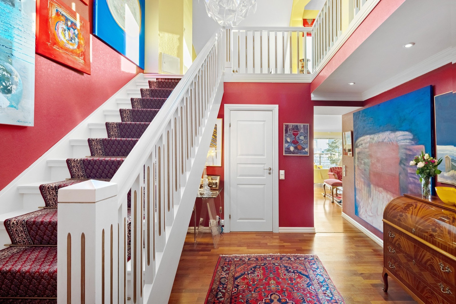 Fra overbygd privat inngangsparti kommer du inn i leiligheten. Entreen er romslig og gir et fint i inntrykk med parkett, downlights og rødmalte vegger. Galleribilde