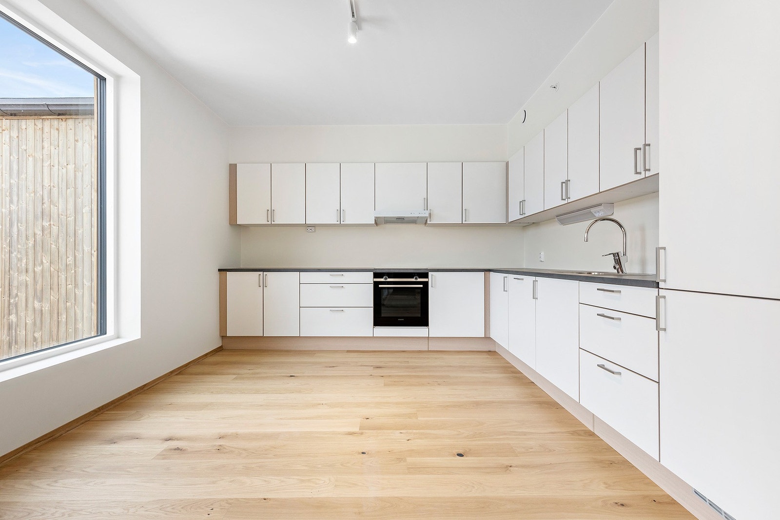 Stort kjøkken med mye skap- og benkeplass. Her får du tidløse fronter og integrerte hvitevarer. Galleribilde