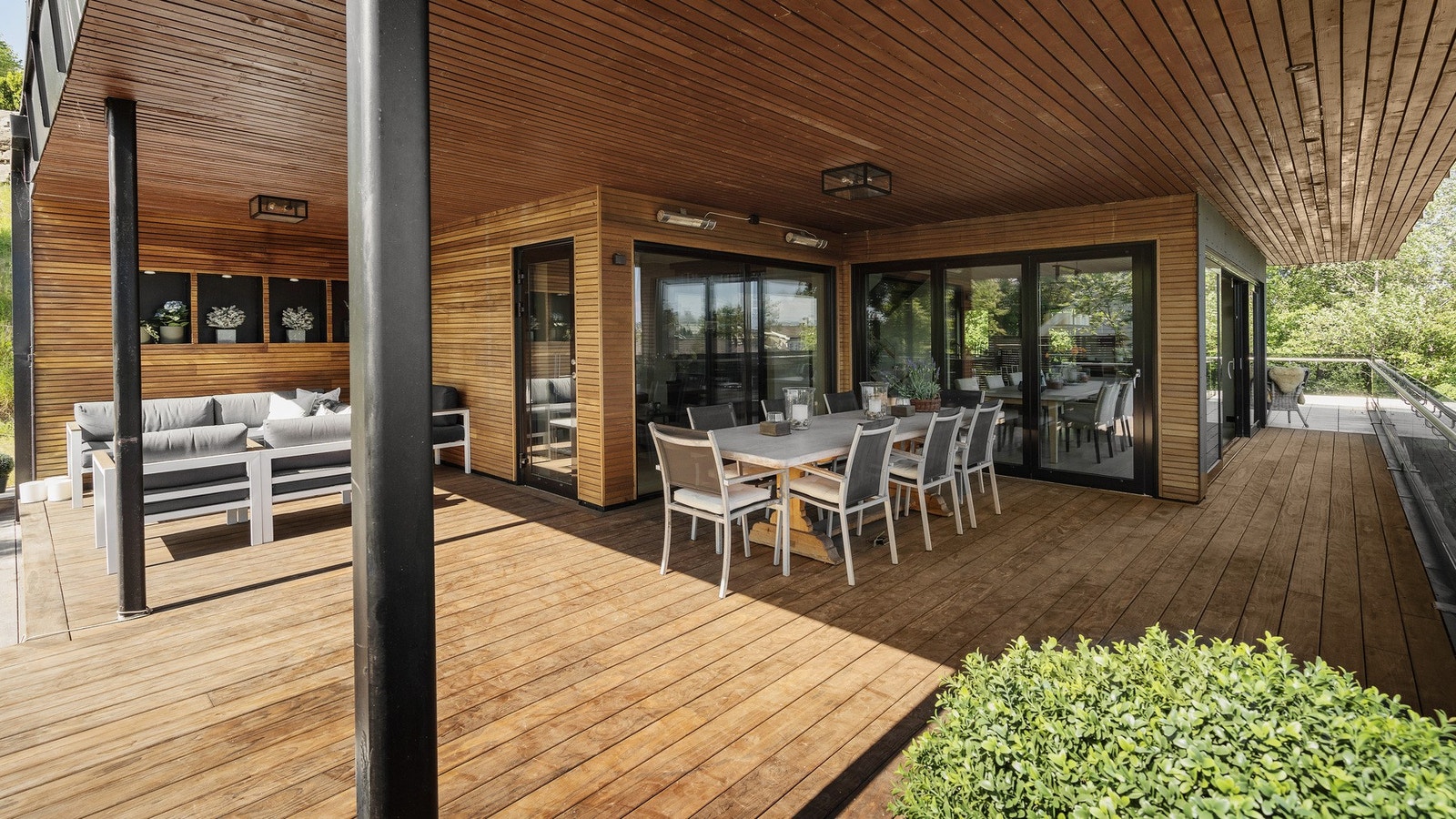 Overbyggede store terrasser med gulv og Afrikansk Sapelii på veggene gir et ekslusivt og varmt utrykk Galleribilde