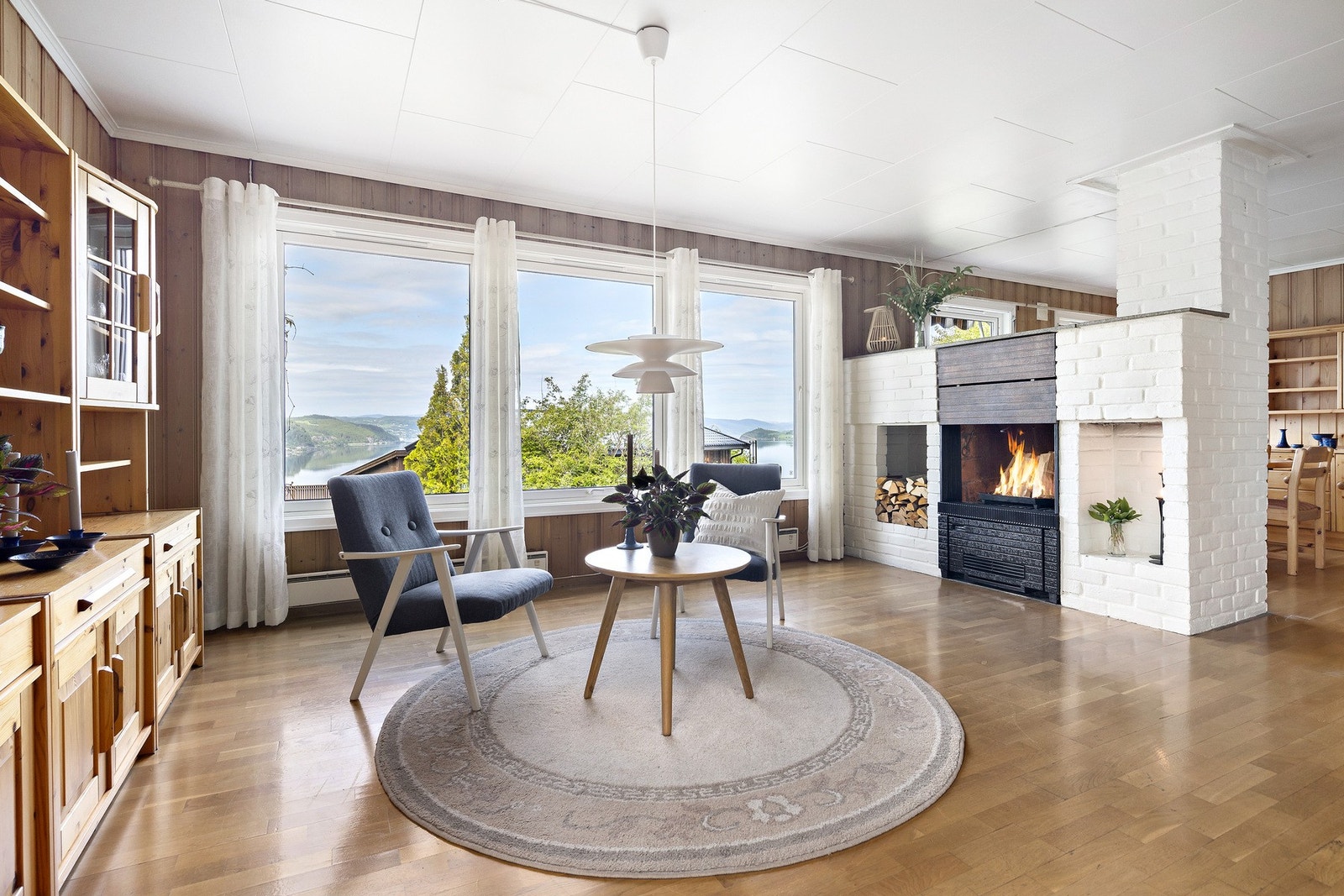 Stuen har flere store vinduer som sørger for rikelig med naturlig lys i rommet. Galleribilde
