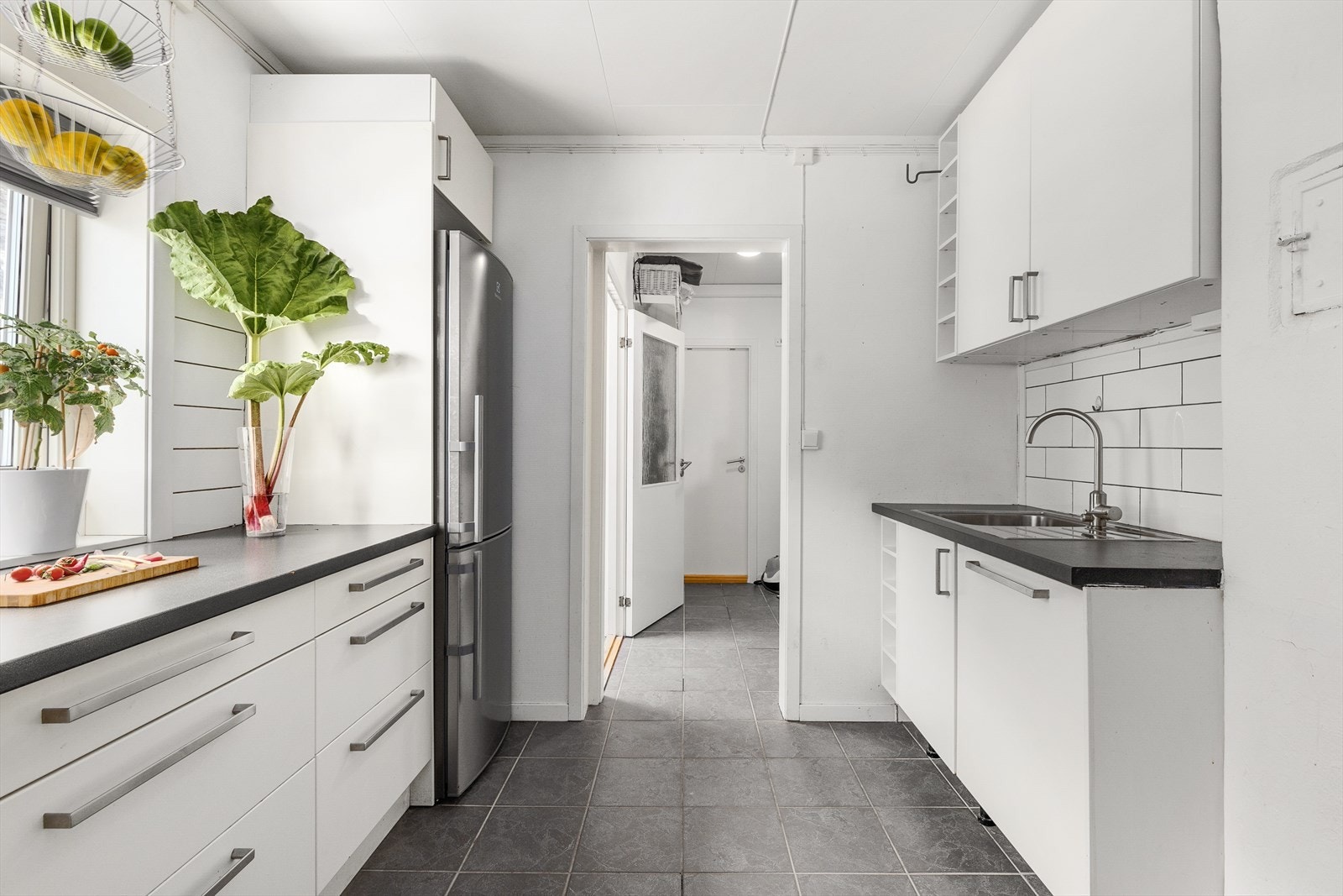 Lys og på kjøkken innredning med glatte fronter og laminert benkeplate med nedfelt kum. Galleribilde