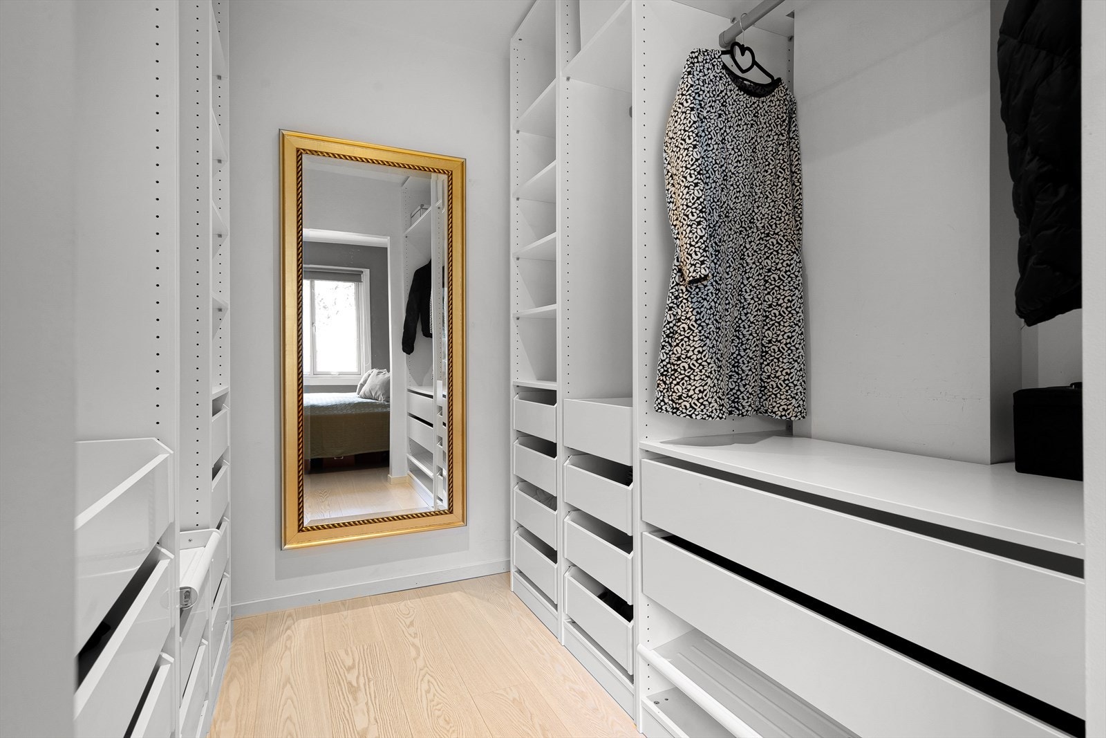 Walk-in garderoben har praktiske løsninger, hyller, skuffer og garderobestenger. Galleribilde