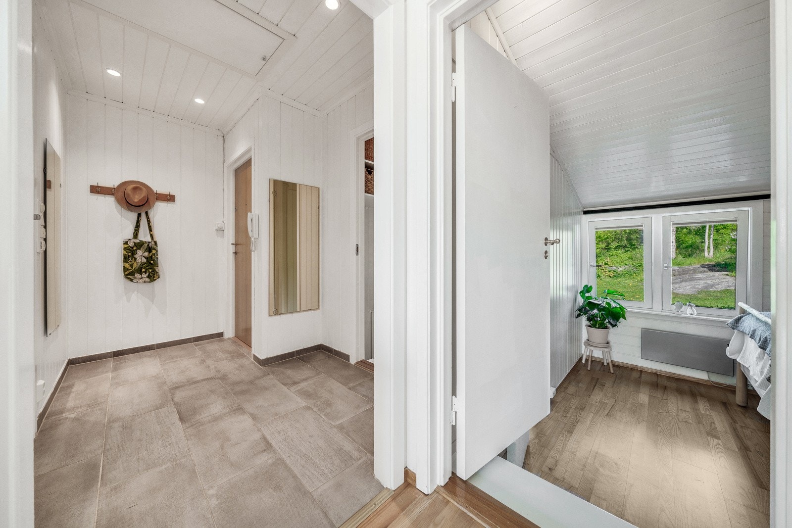 Entréen er innbydende med flislagt gulv og hvitmalte veggflater. Det er gulvvarme og downlights i himlingen Galleribilde