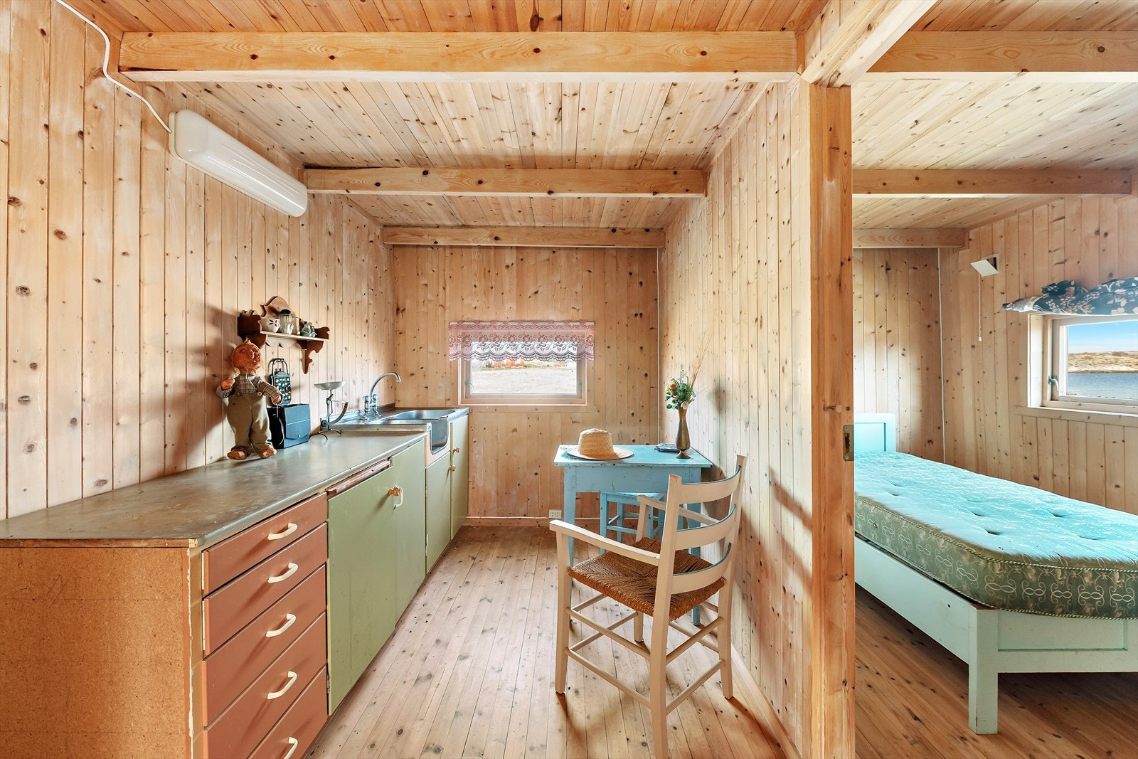 Via gangen/bislaget kommer du inn i boligens kjøkken. Innredningen er enkel med malte slette fronter og utslagsvask med to-greps blandebatteri Galleribilde