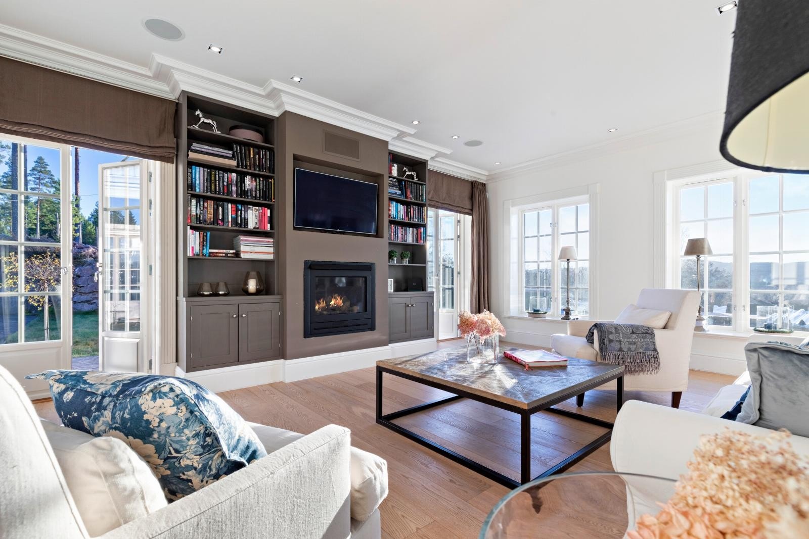 TV-stuen er innredet med delikate plassbygde skap, hyller og en moderne gasspeis som gir et ekslusivt preg. Galleribilde