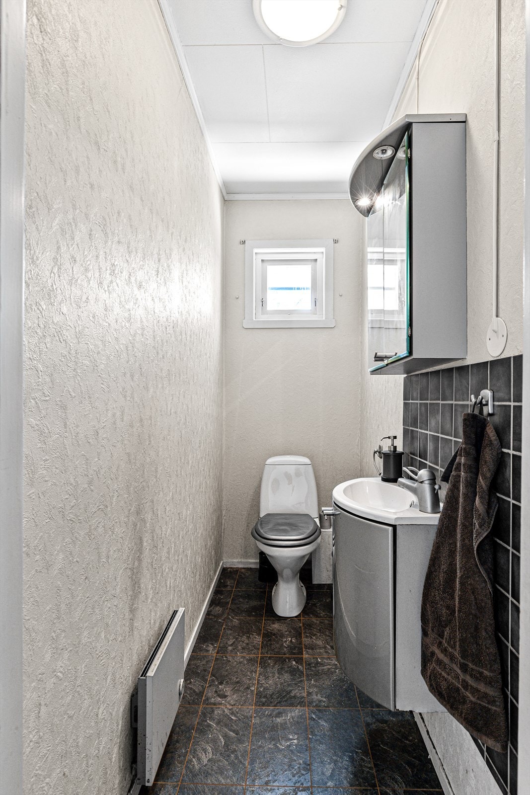 Det separate toalettet består av gulvmontert klosett, servant med ett-greps kran og speilskap med lys over. Naturlig avtrekk Galleribilde