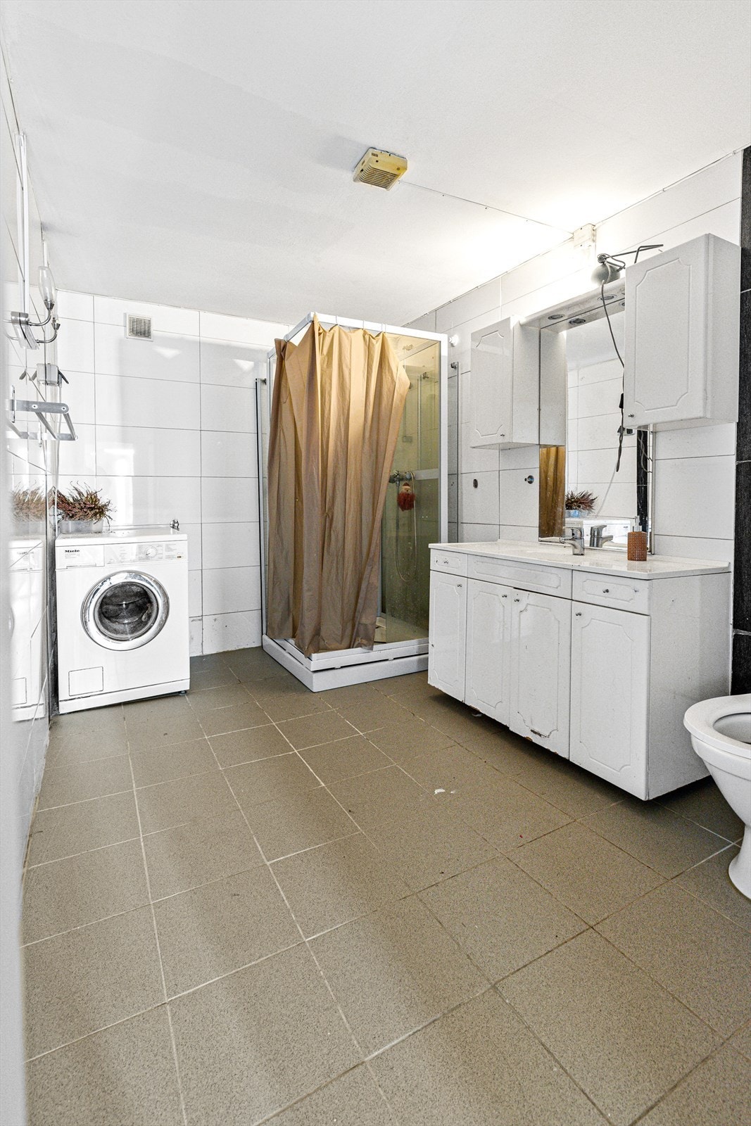 Det flislagte badet (del1) er fra 2018 og har varmekabler i gulv. Arbeidet som er gjort kan ikke dokumenteres. Videre består badet av dusjkabinett, servantskap med heldekkende servant, 2 vegghengte skap, vegghengt speil med lys over og toalett Galleribilde