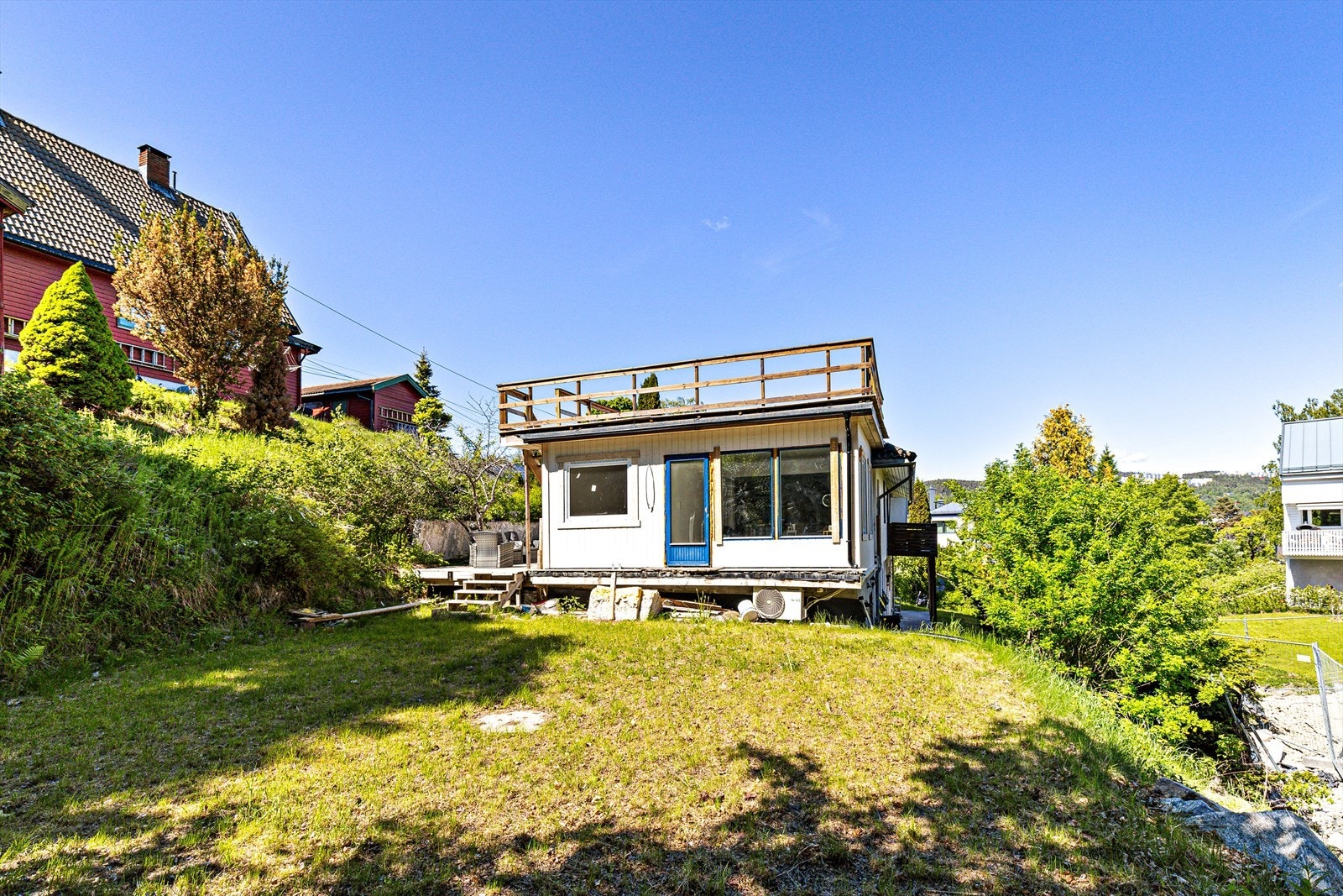 Den solrike hagen er pent anlagt med en kombinasjon av frodig plen, velstelte hekker og varierte trær Galleribilde