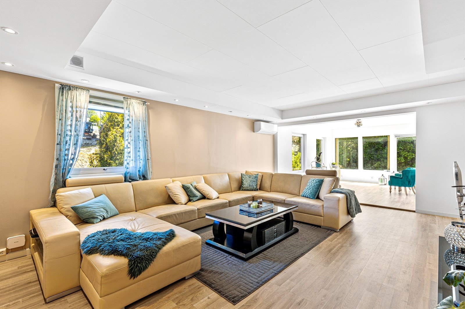 Moderne og stilren stue hvor det ble montert downlights i tak i 2018. Det nøytrale fargepalettet og de minimalistiske møblene skaper en luftig atmosfære, mens innslag av levende grønne planter tilfører en friskhet til rommet Galleribilde