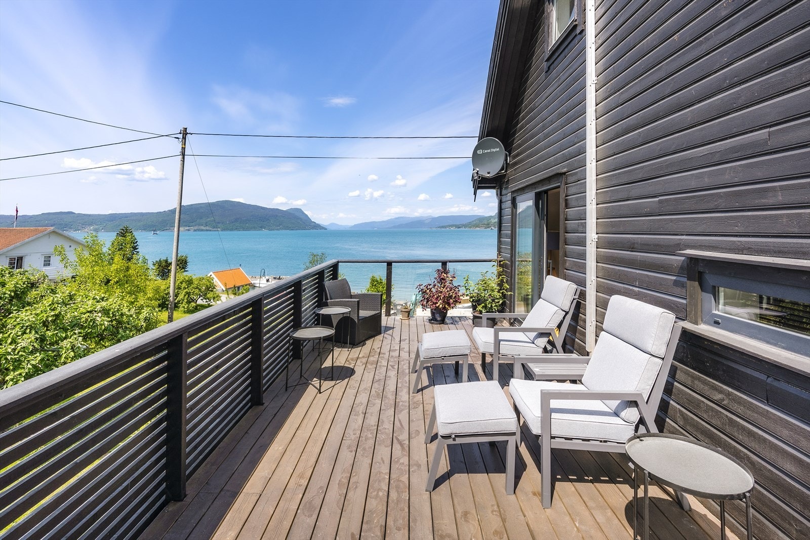 Nyere terrasse på 3 av sidene på boligen. Her ved utgang fra spisestue. Galleribilde