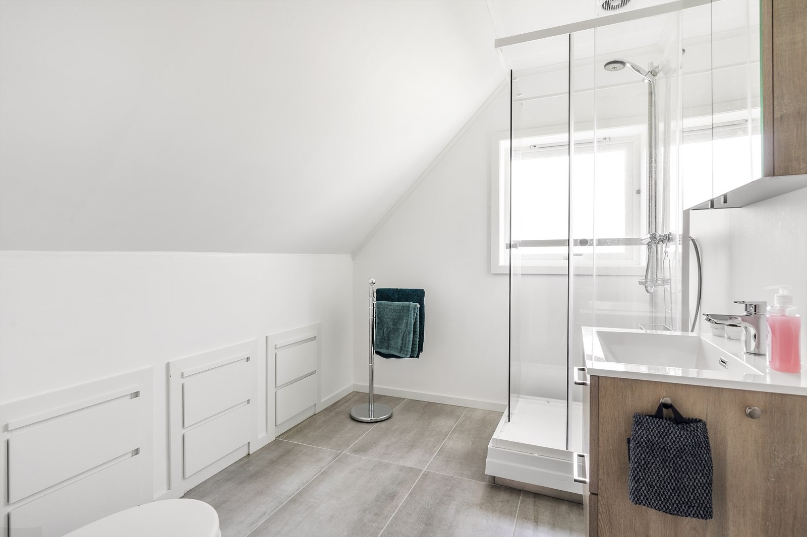 Bad på loft med nyere fliser på gulv. Dusjkabinett ble satt inn i forbindelse med renovering av bad i 1.etasje og har kun avløp koblet på servant. Galleribilde