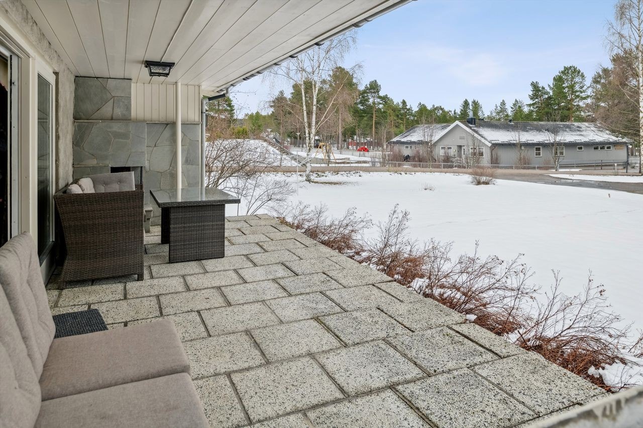 Fra stuen er det utgang til en hellelagt terrasseplatting med murt, åpen utepeis i hjørnet mot sør. Galleribilde