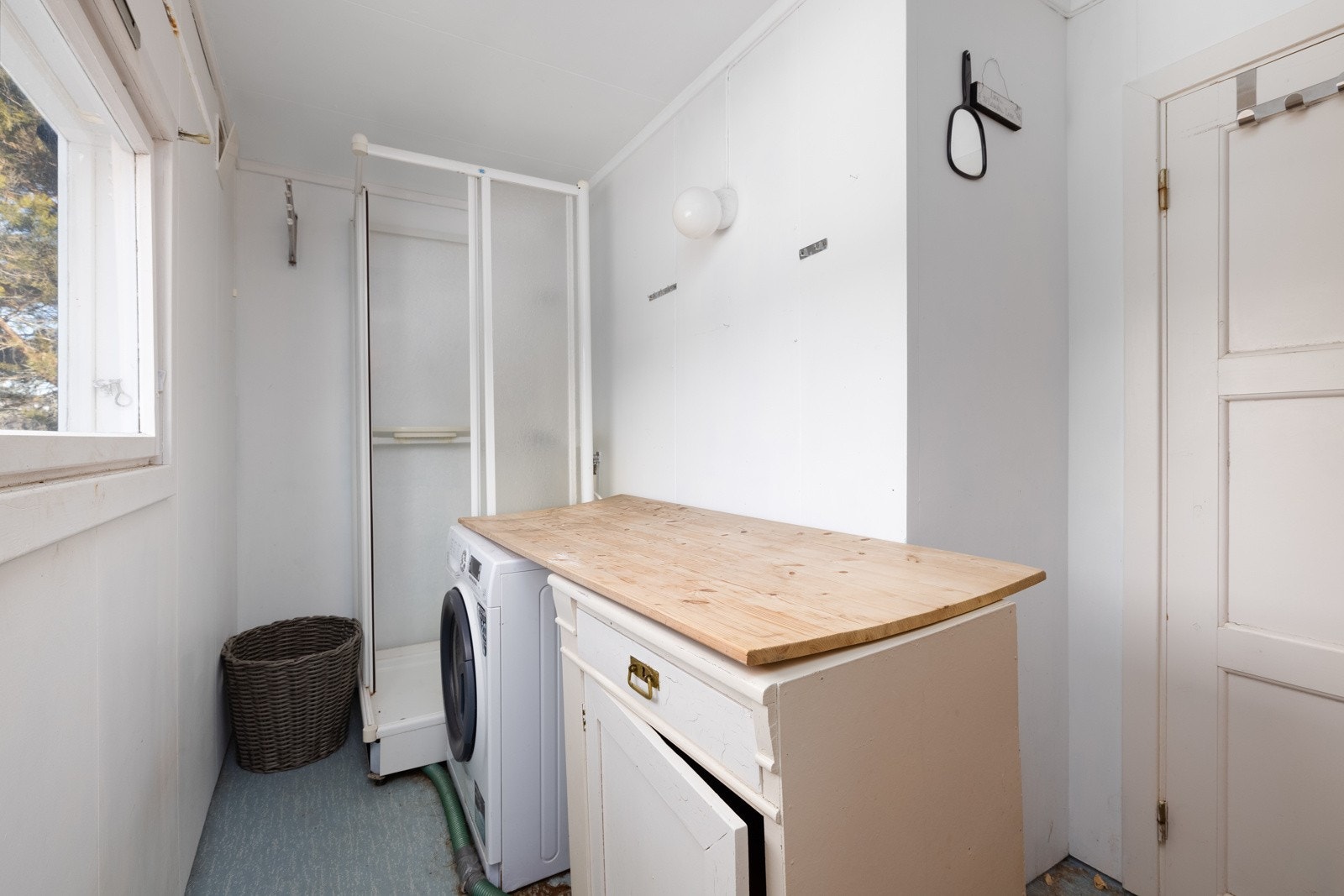 Vaskerom innredet med dusjkabinett og opplegg for vaskemaskin. Galleribilde