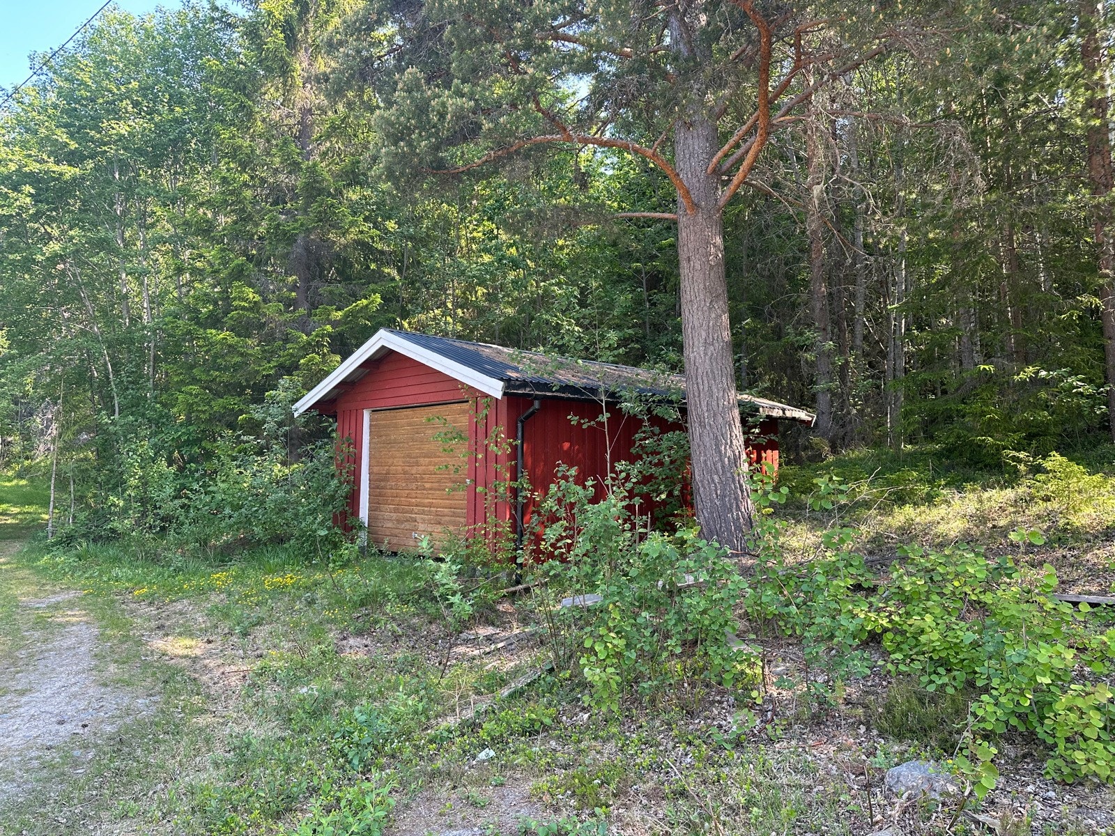 Det ligger en garasje på oversiden av veien tilknyttet eiendommen. Galleribilde