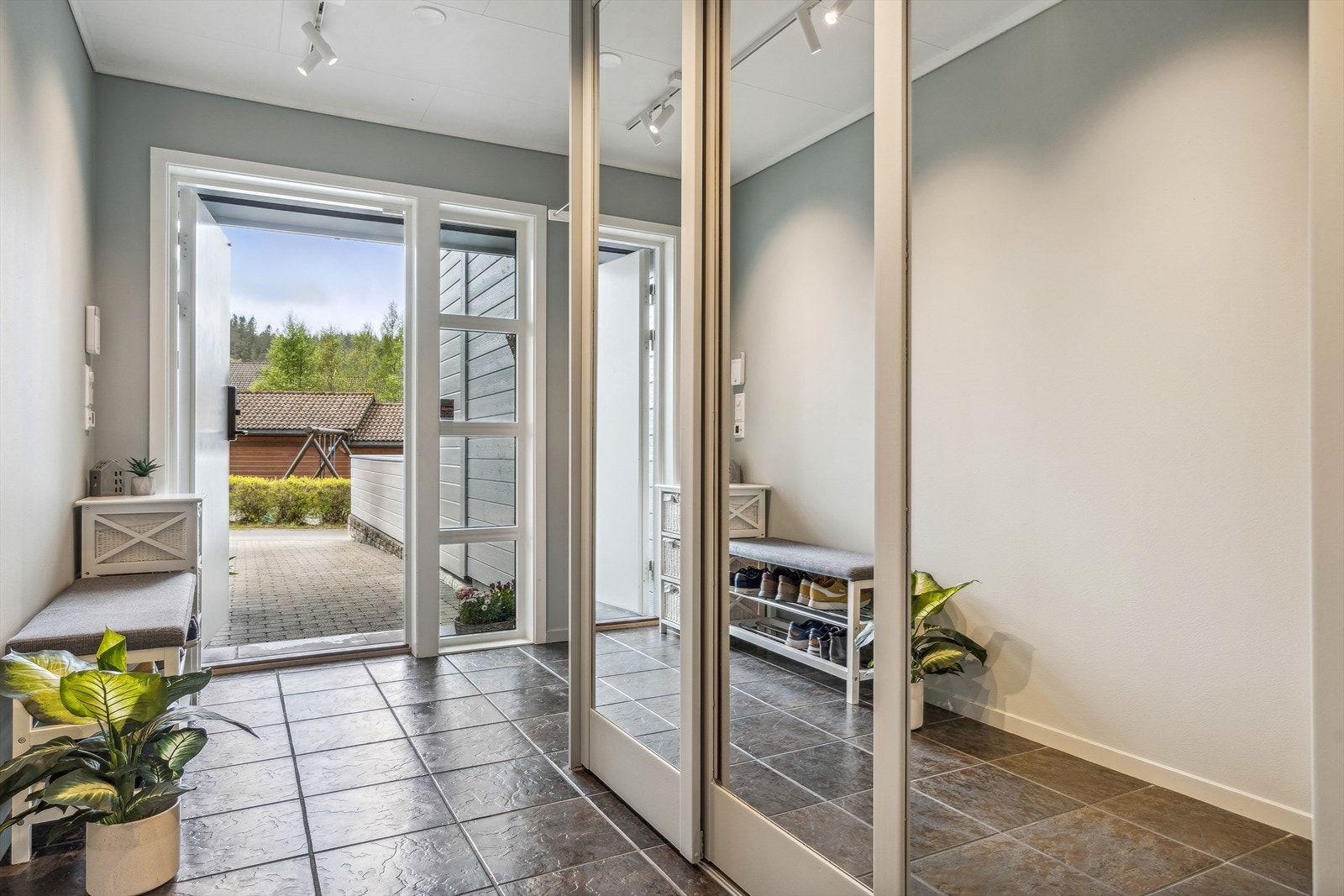 Romslig entré med skyvedørsgarderobe. Fliser på gulv og varme. Galleribilde