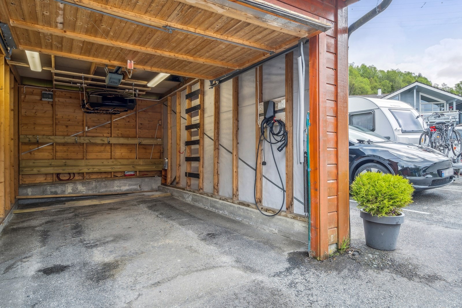 Egen garasje i rekke for en bil. Vippeport med garasjeportåpner. I garasjen er det EL-bil lader som følger med. Galleribilde