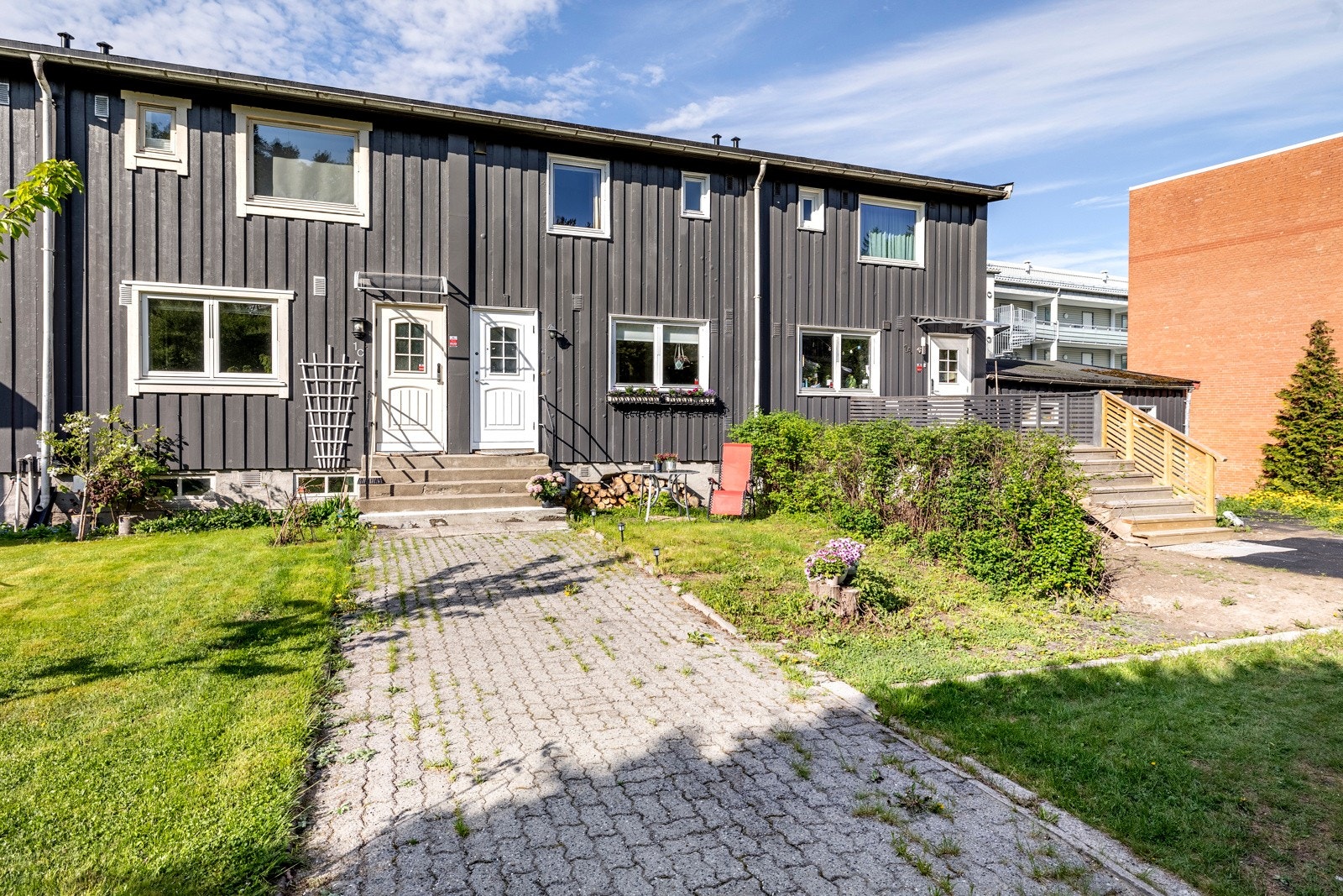 Det er trapp opp til et felles inngangsparti, og en hvit ytterdør med glassfelt fører inn til entreen. Galleribilde