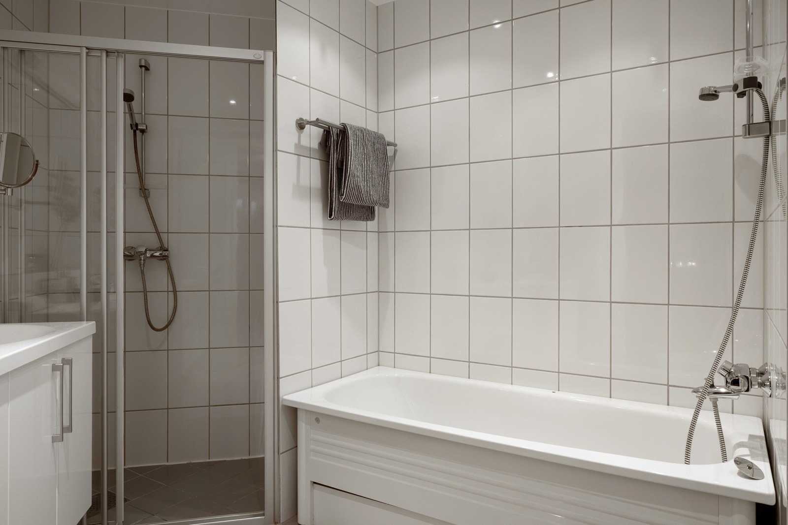 Bad i tilknytning til hovedoverom har badekar, dusj med skyvedør, servant, og veggfestet klosett med innebygget sistere. Galleribilde