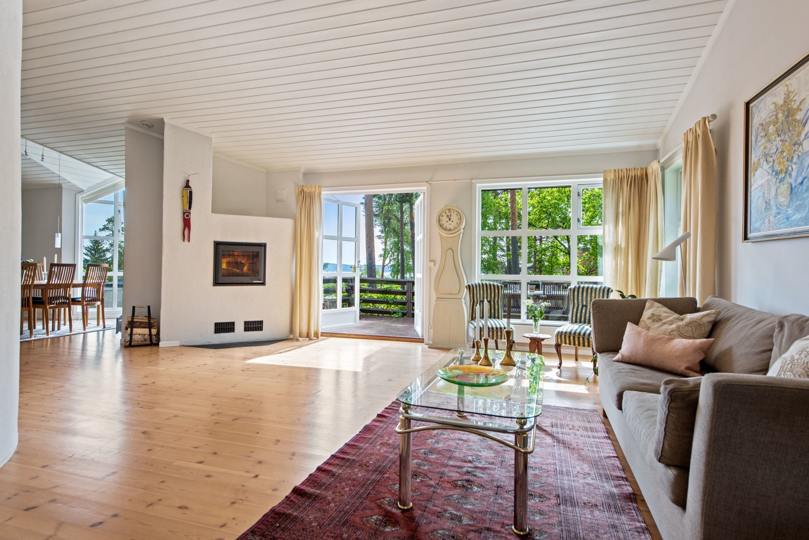 Lyset og solen får strømme fritt inn i stuen. Den flotte peisen skaper kos og hygge. Galleribilde