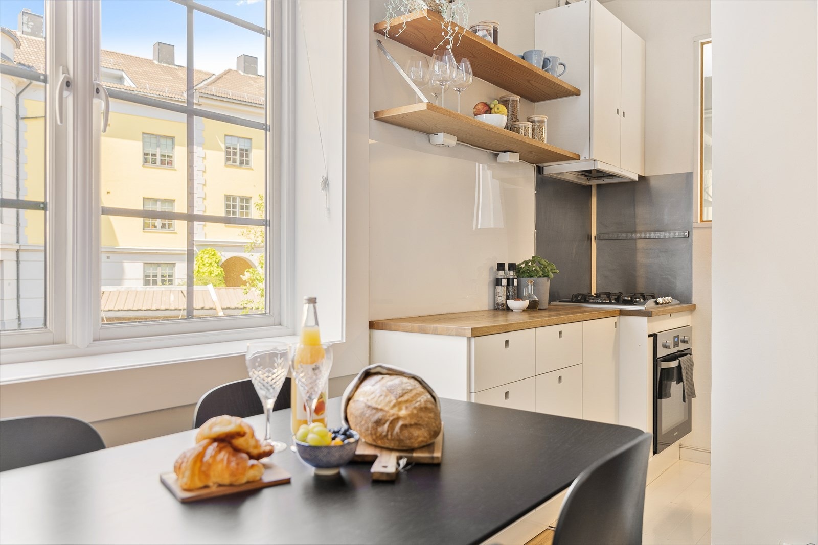 Kjøkkenet har en arealeffektiv kombinasjon av skap- og benkeplass for oppbevaring og matlaging. Galleribilde