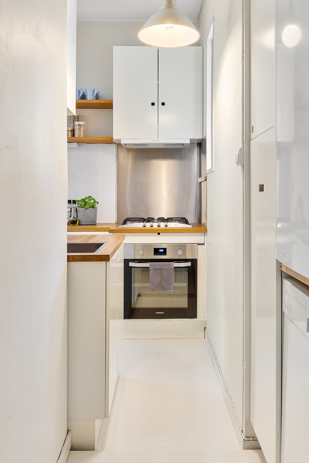 Kjøkkenet har hvite fronter. Galleribilde