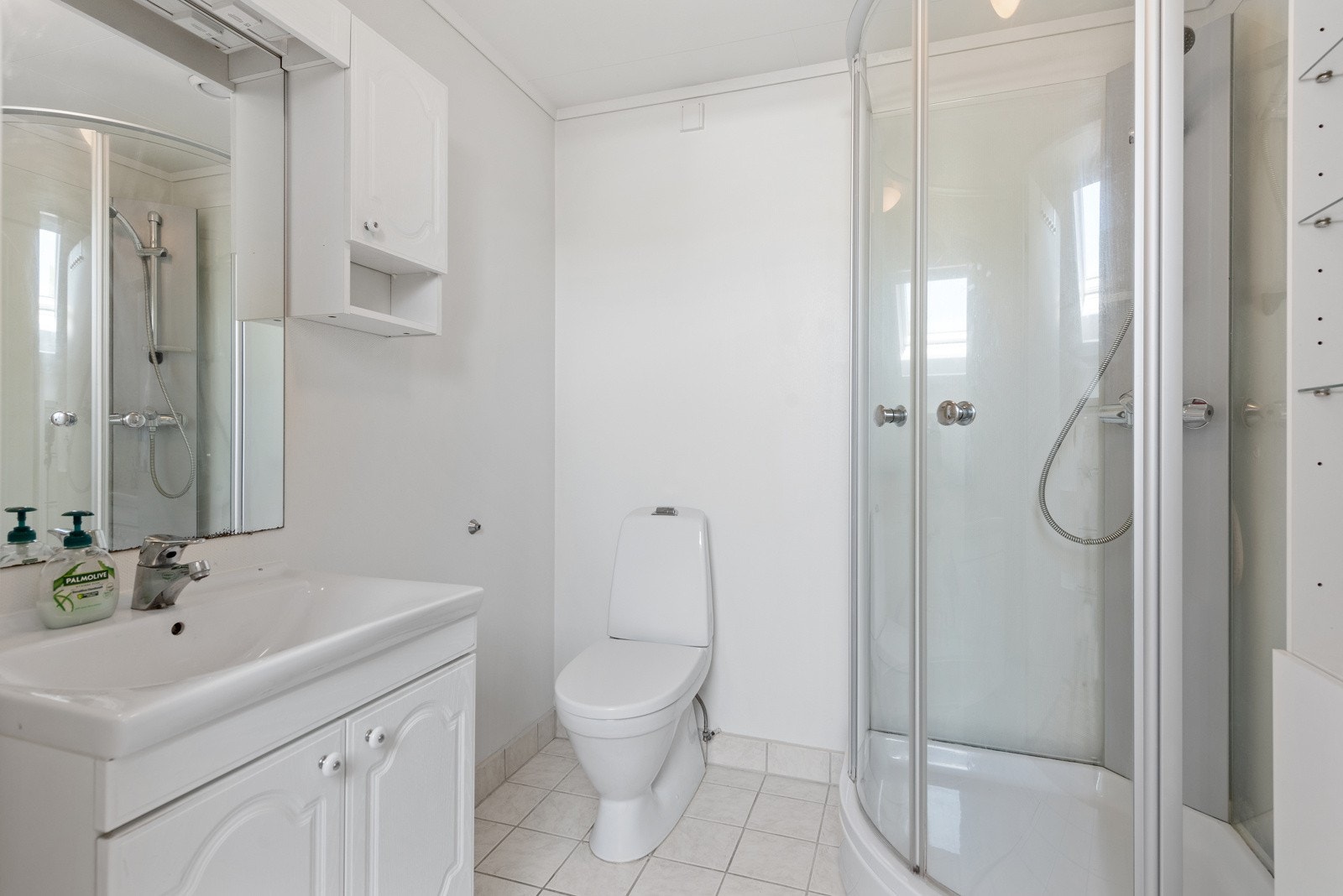 Badet i 2. etasje er utstyrt med gulvmontert toalett, dusjkabinett, skap med servant, veggskap og speil med belysning. Galleribilde