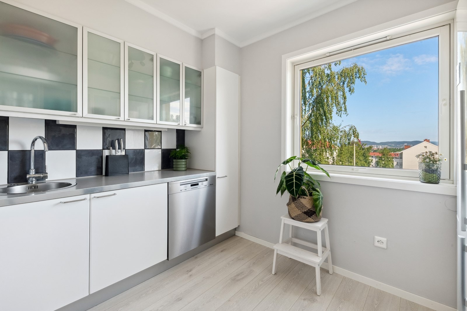 Separat IKEA kjøkken fra 2004 med glatte, folierte fronter og vitrinedører som overskap. Galleribilde