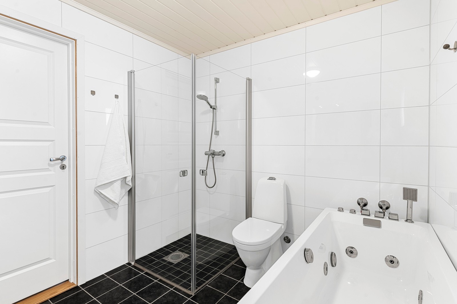 Rommet har servantinnredning og tilhørende veggskap på hver side av speil med belysning. Galleribilde