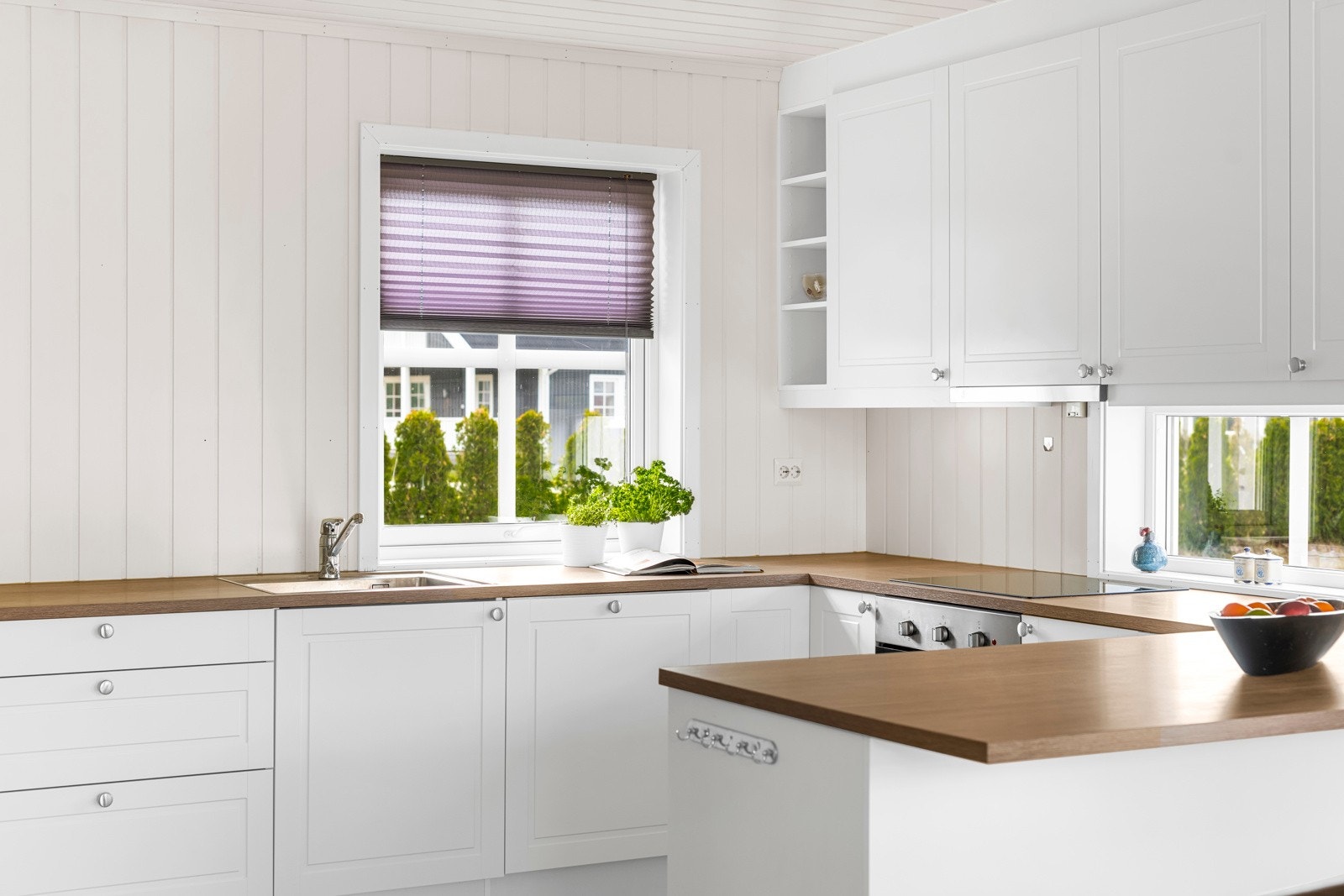 Over kjøkkenbenken er det belysning og vinduer med fint utsyn til omgivelsene. Kjøkkenet har medfølgende integrerte hvitevarer i form av stekeovn, induksjonstopp, kombinert kjøl/frys, oppvaskmaskin og ventilator. Galleribilde