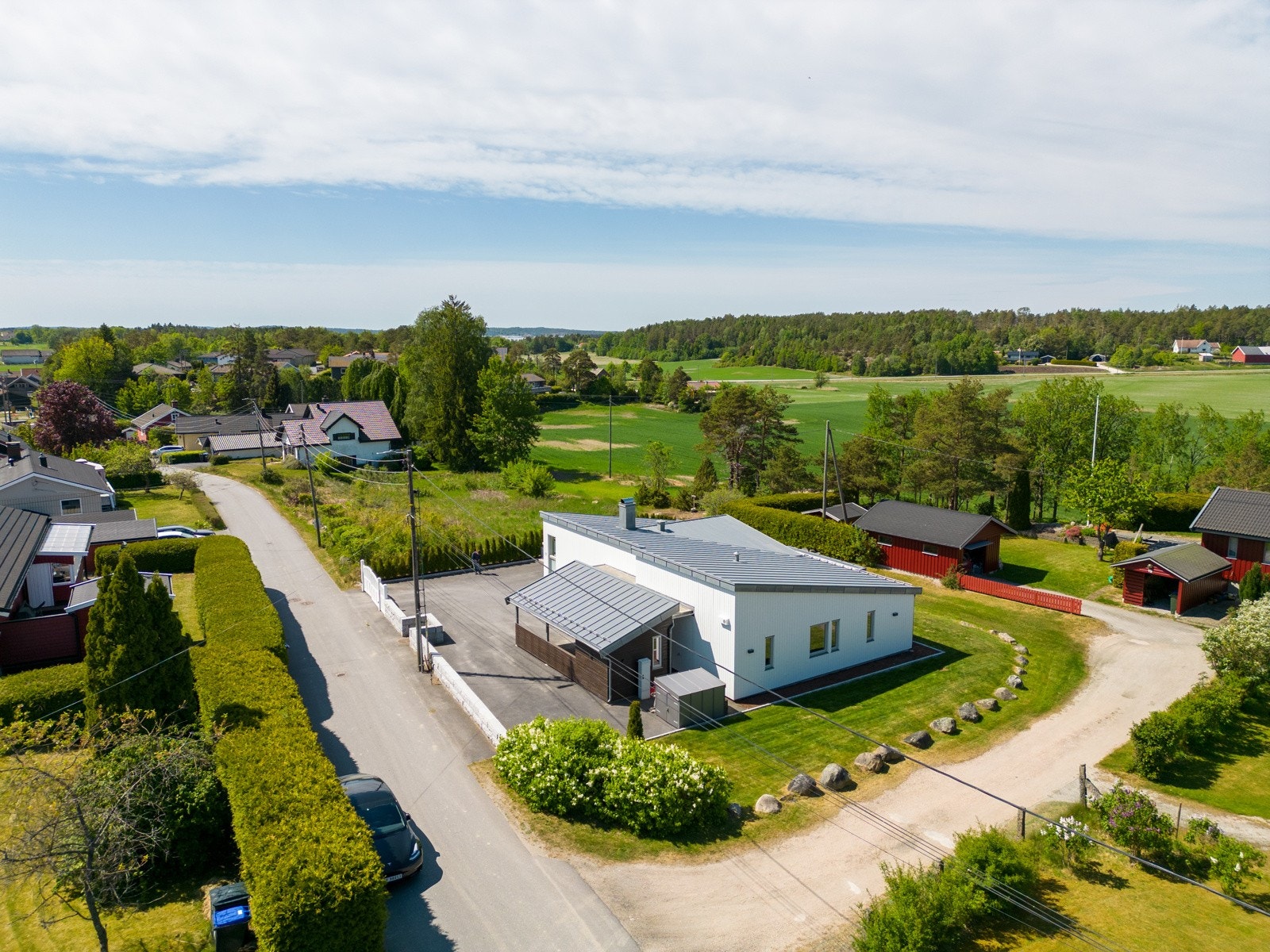 Deler av eiendommen er inngjerdet med hekkbeplantning og granittmur. Inngangspartiet har en hvit, klassisk port mot gaten. Galleribilde