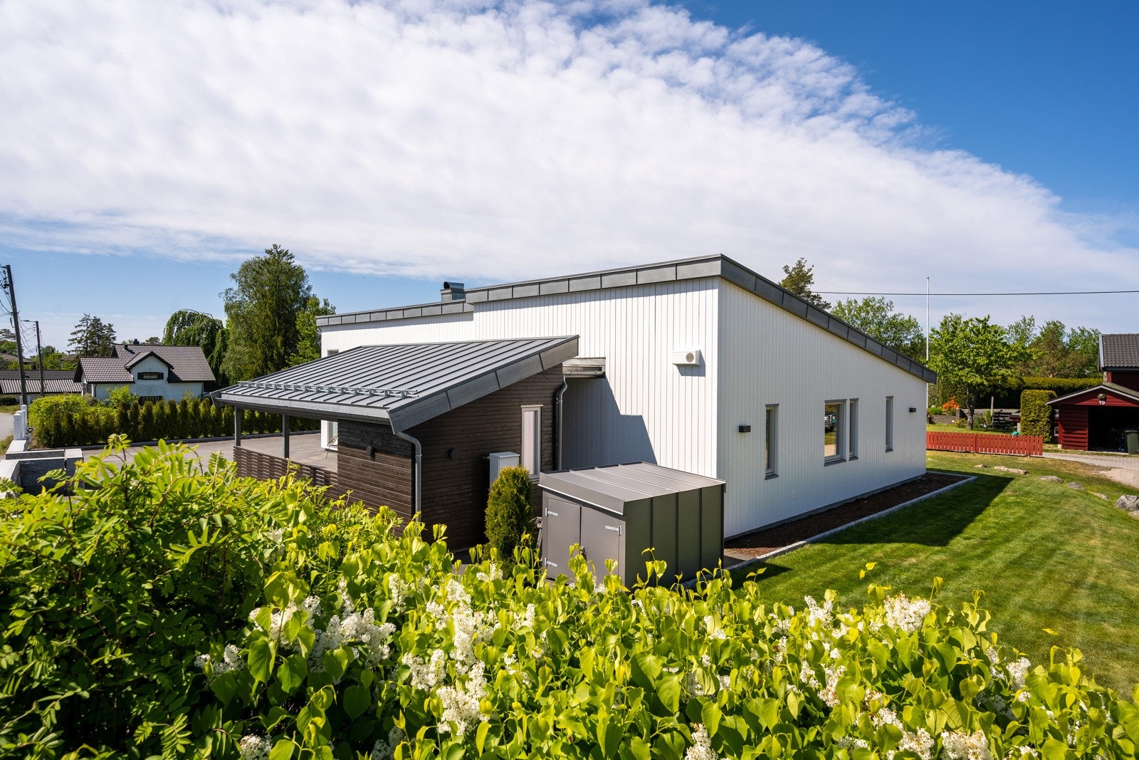 Tomten er flat og fint opparbeidet med gress og prydbeplantning. Galleribilde