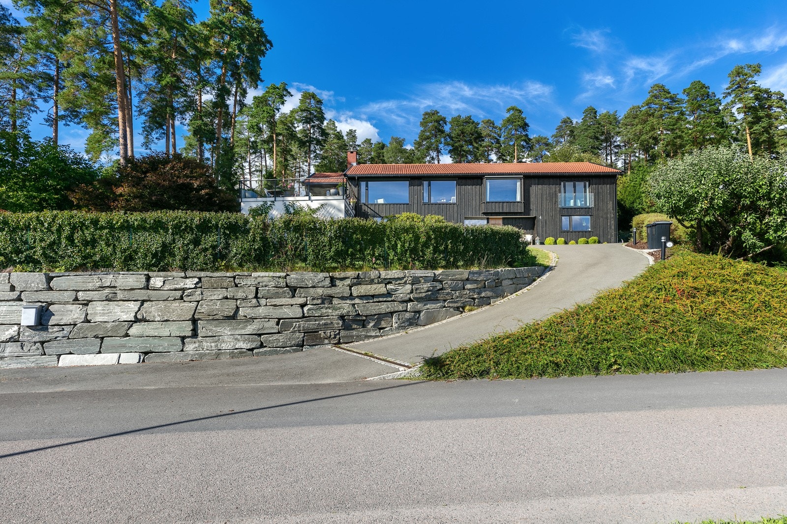 Over støttemuren er det plantet hekk og i denne delen av hagen står også et uthus fra 2016 på ca. 14 kvm. Galleribilde