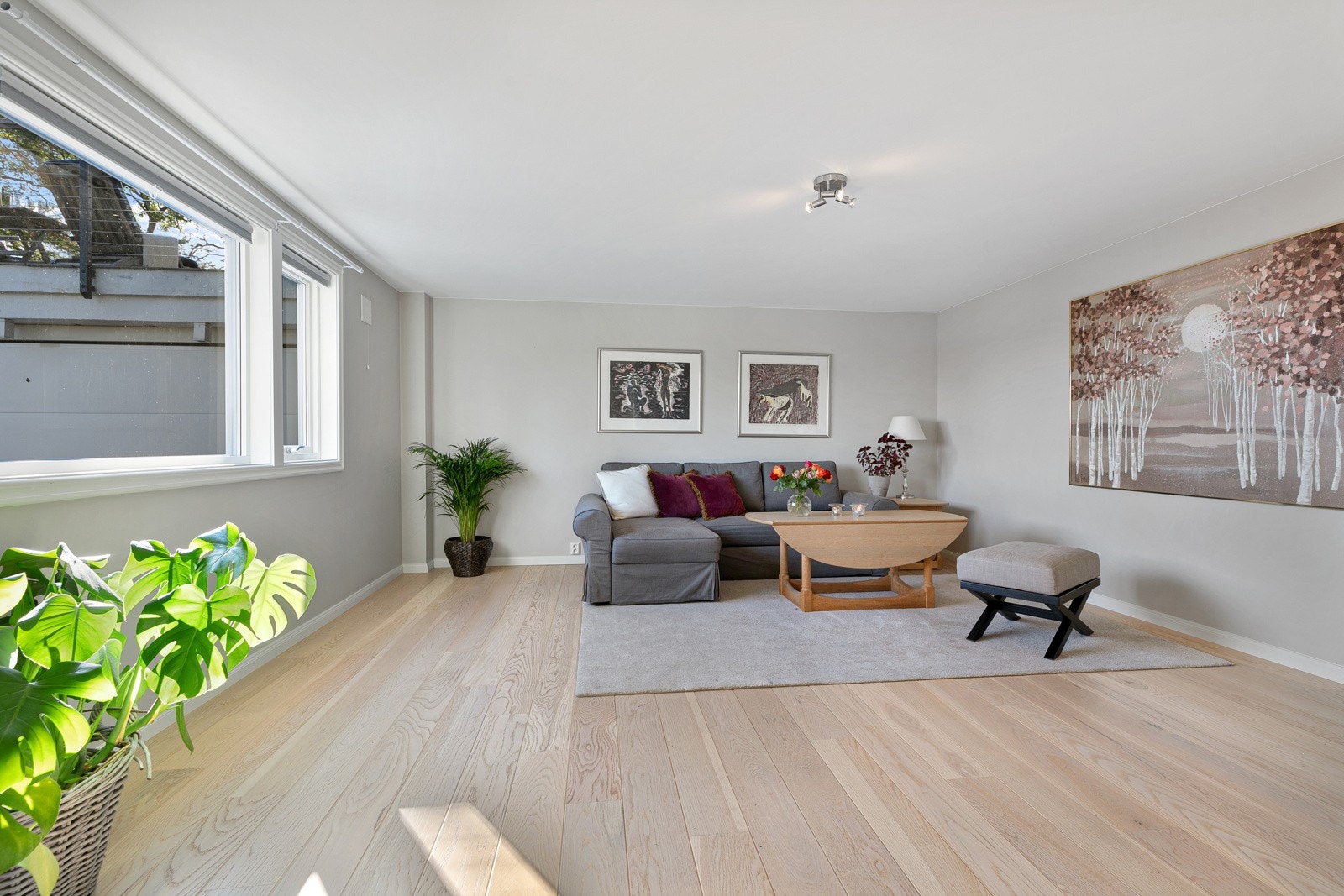 I underetasjen er det en lys og fleksibel stue med fjordutsikt. Rommet har enstavs parkettgulv, gråmalte vegger og god plass til en sofagruppe og tv-løsning. Galleribilde