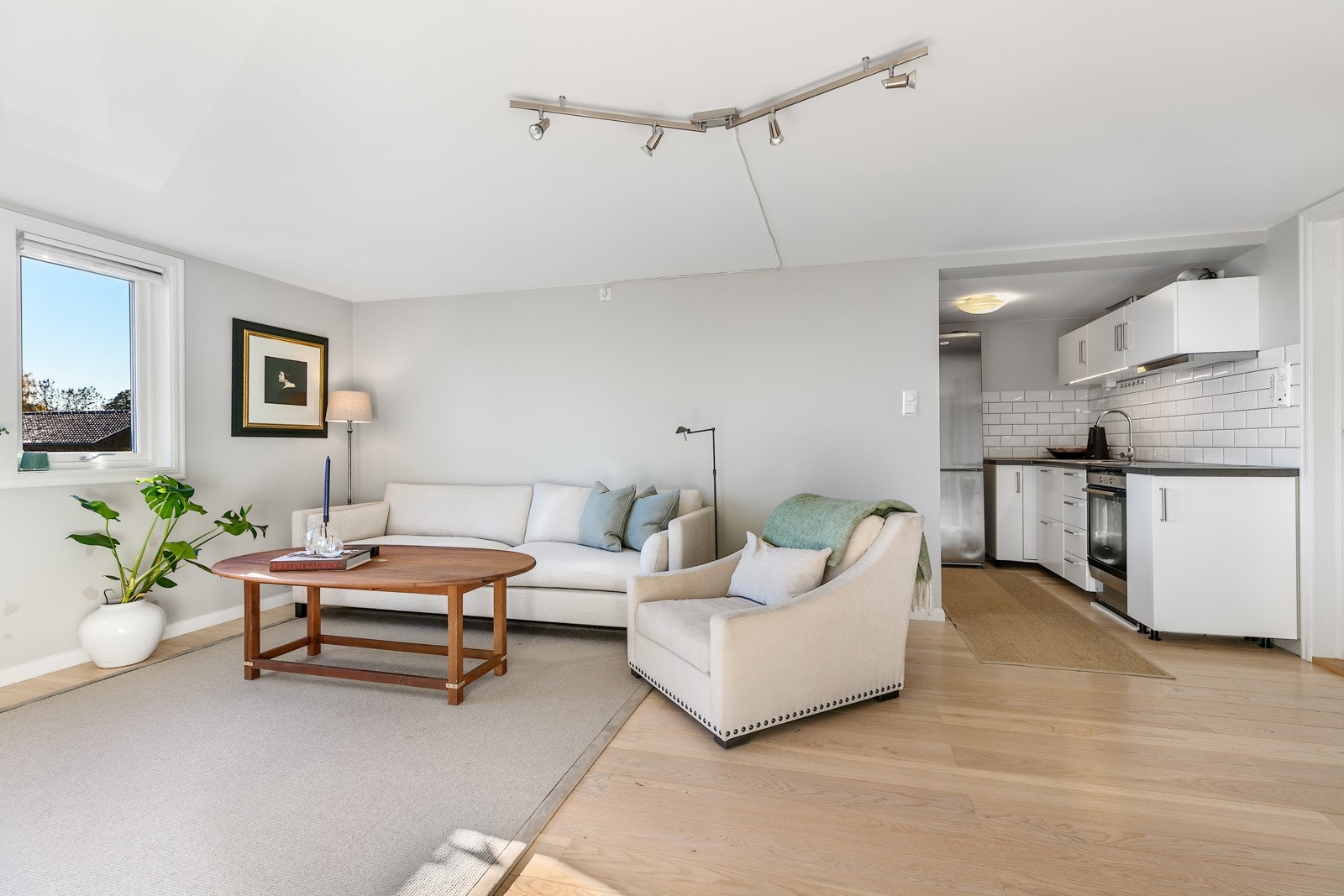 Stuen har enstavs parkettgulv, lysegrå veggflater, listefritt tak, samt plass til både sofa og spisebord. Vinduer på to sider gir godt med dagslys og vakker fjordutsikt. Galleribilde