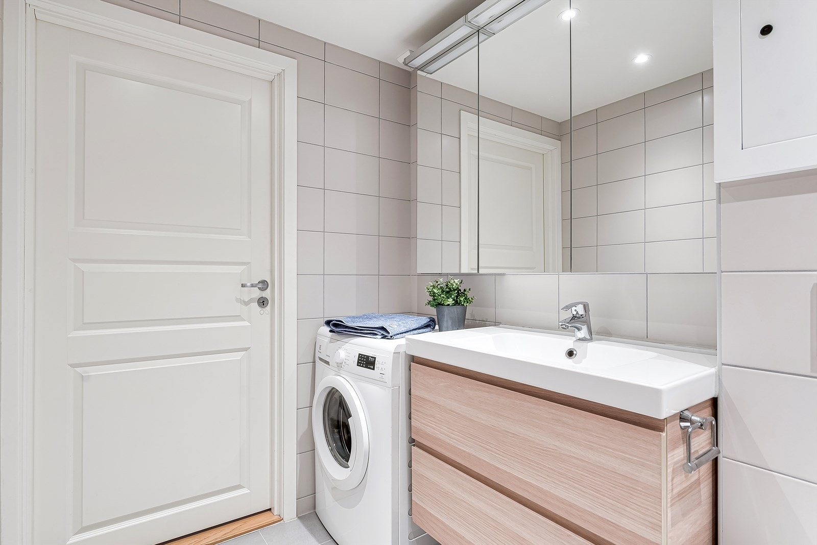 Stort bad med vaskesøyle, servant, med servantskap, speilskap, dusjnisje og vegghengt wc Galleribilde