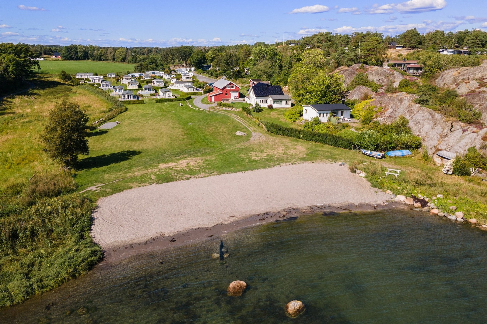 Flott strand ligger bare 500 m fra tomta. Her sees også Sjørosen camping Galleribilde