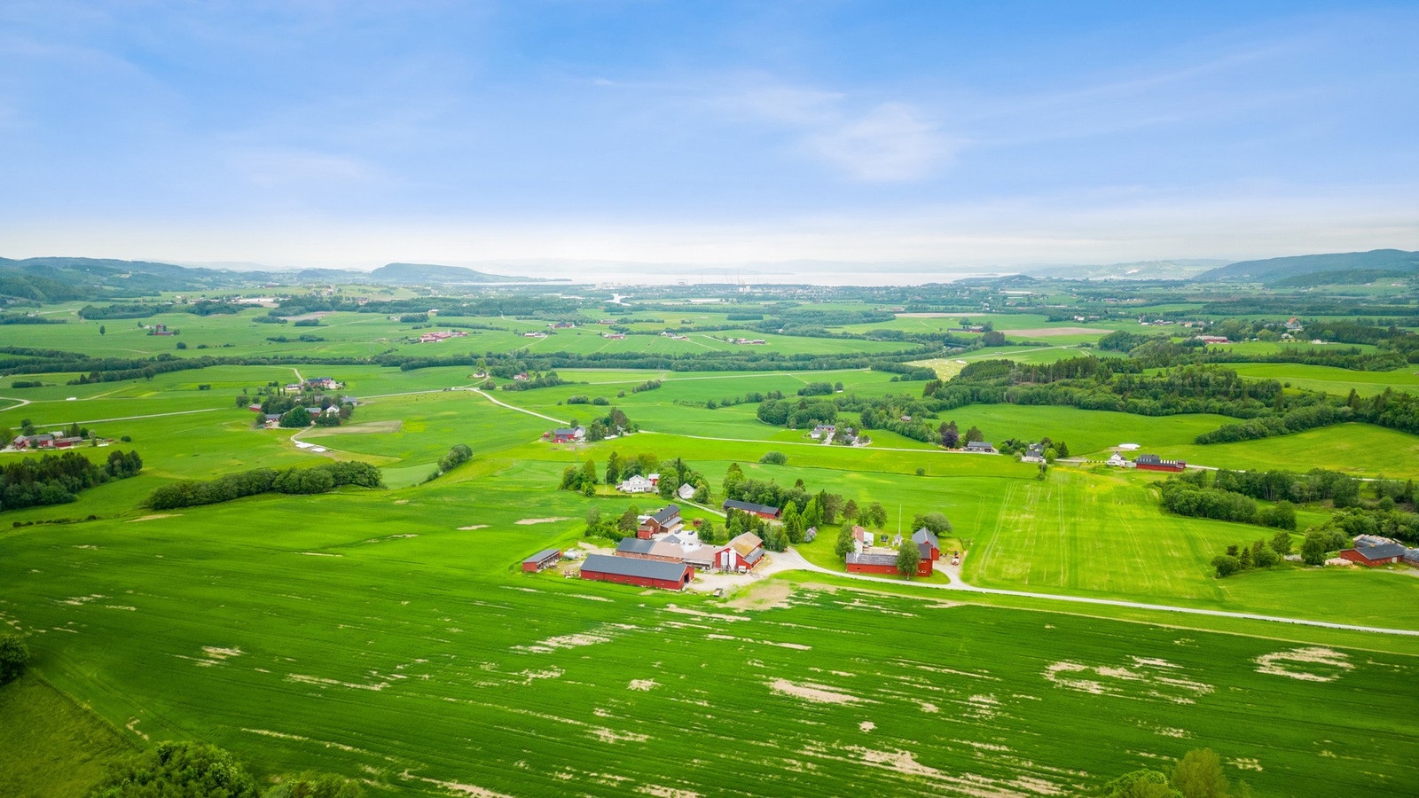 Oversiktsbilde over gården og området. Verdal sentrum som man ser mot sjøen. Galleribilde