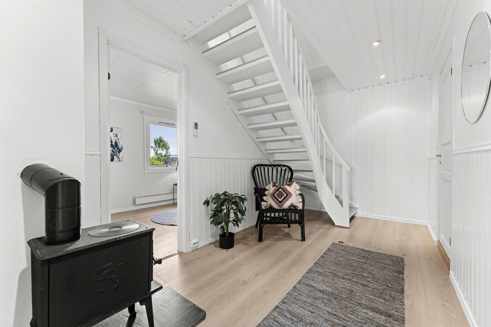 Hallen i lyse farger og med egen vedovn Galleribilde