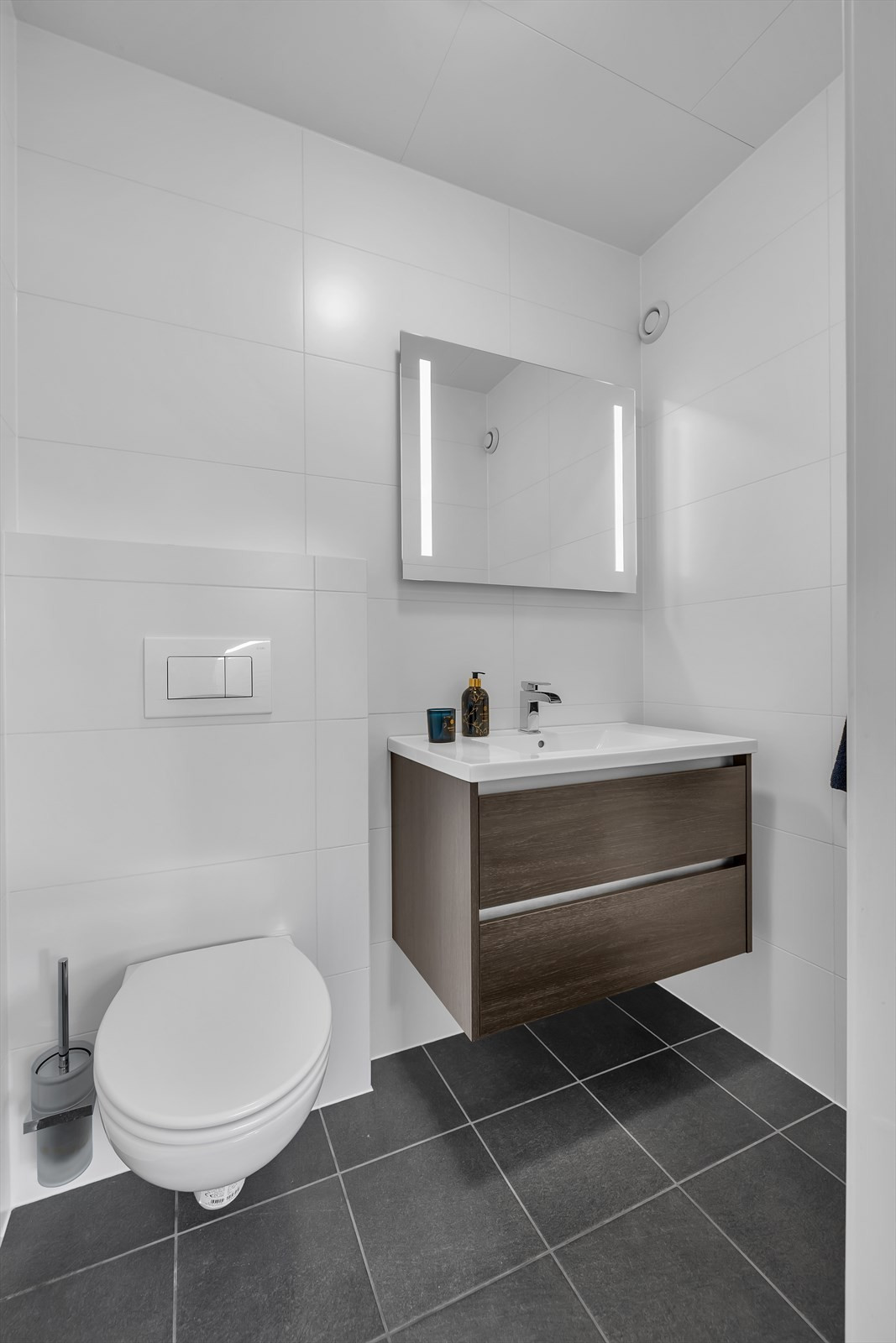 Toalettrom med vegghengt wc og moderne innredning.