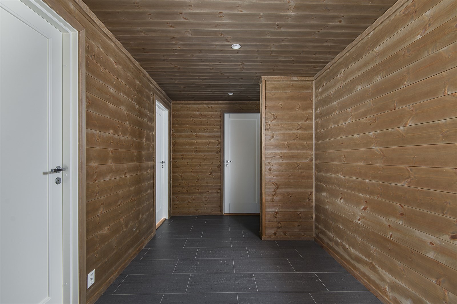 Gangen har fliser med gulvvarme og fører en videre til hyttas øvrige rom Galleribilde