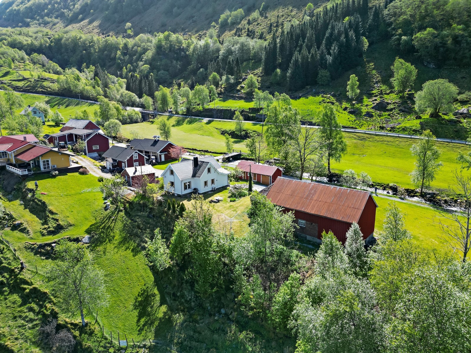 Småbruket er utbygd med bolighus, uthus/garasje, låve og 2 naust Galleribilde
