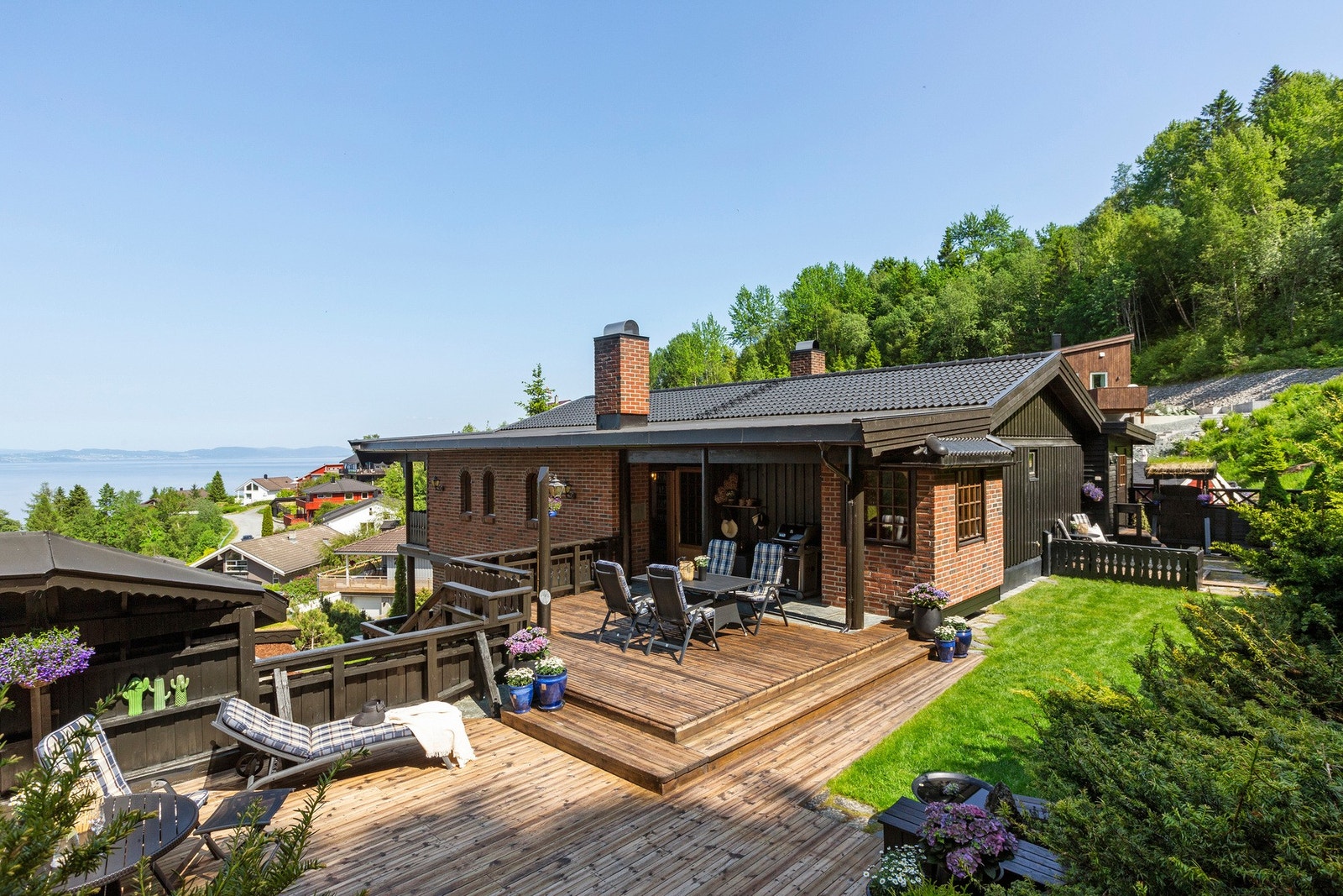 Utearealene er på ulike nivåer, fra stue og kjøkken er det adkomst til en lun uteplass med både terrasse og plen. Galleribilde