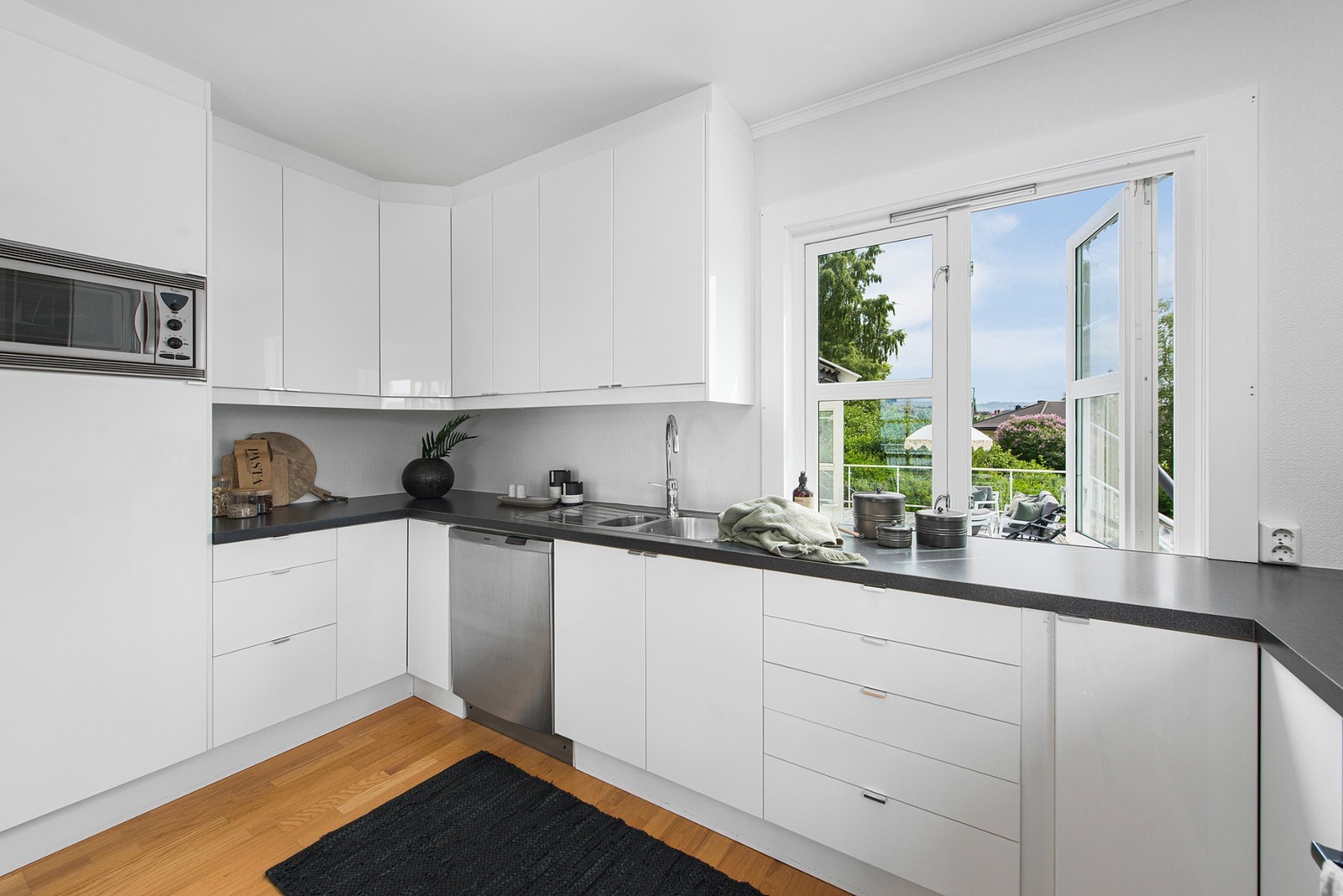 Hvitt høyglanskjøkken med integrerte hvitevarer. Galleribilde